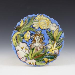 Piatto con volto femminile e decoro floreale